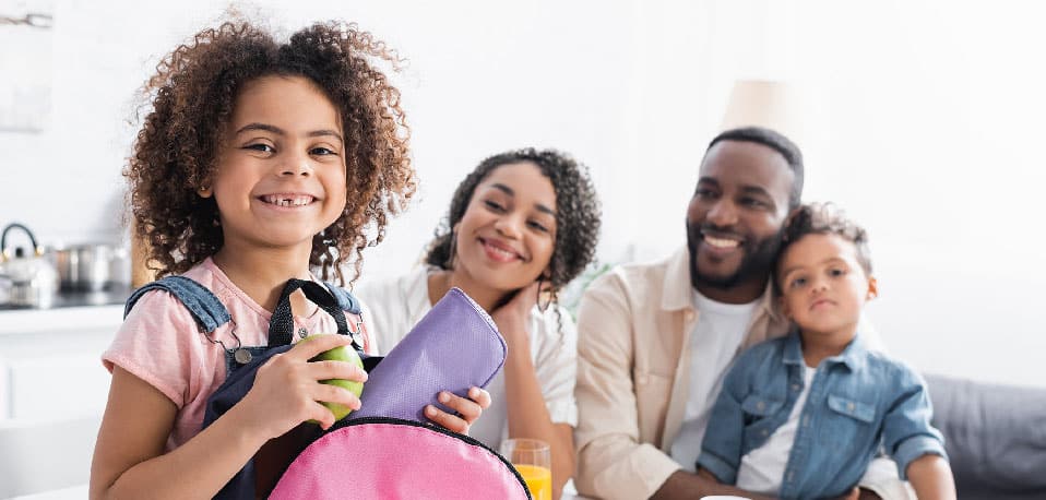Black family with mother, father, son and daughter. Daughter is in foreground
