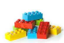 Colorful plastic toy building blocks stacked in a small pile on a white background.