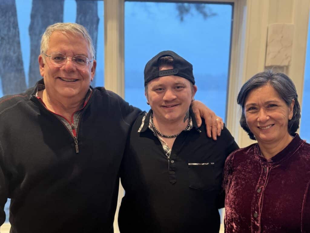 Three people smiling together for a photo.